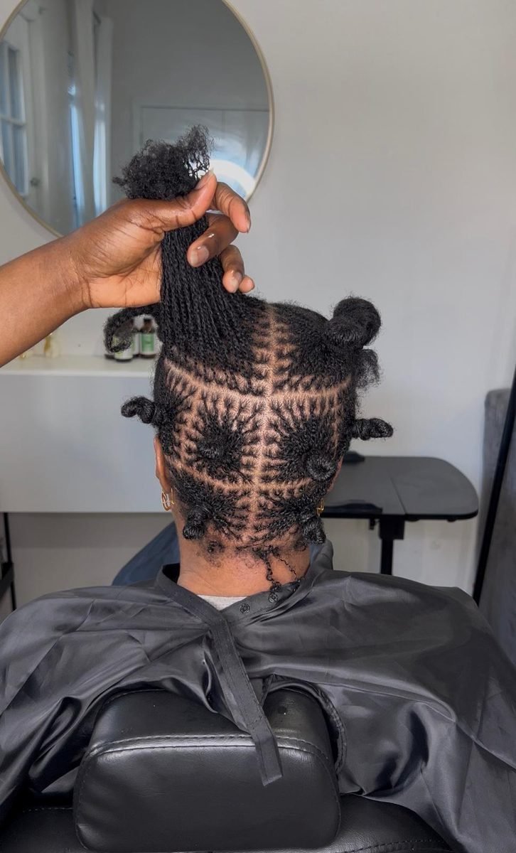 Stylist hand sectioning hair during a microloc installation at Locs by Hair Arena
