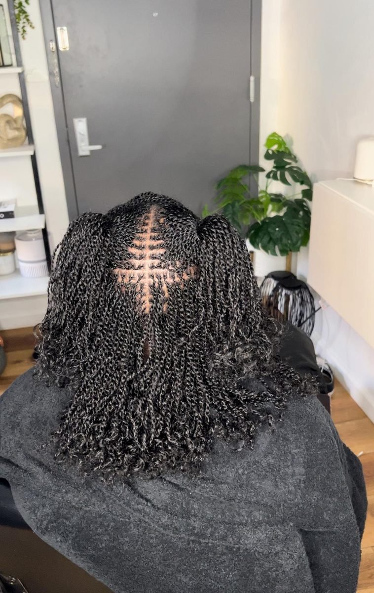 Client with natural salt and pepper grey twists and center chevron parting